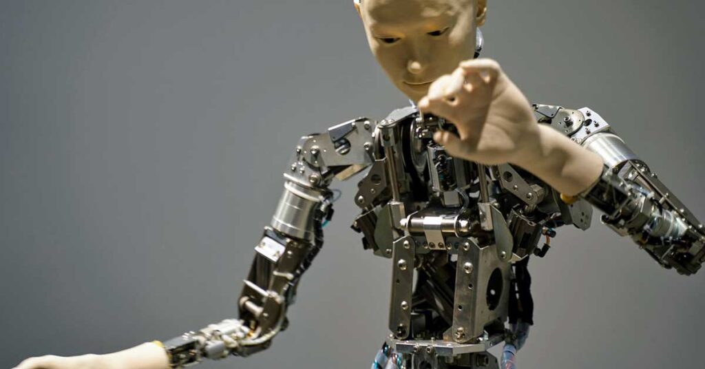 A metallic robot with a hand, symbolizing advancements in AI, robotics, and digital technology.  Photo: マクフライ 腰抜け from Pixabay